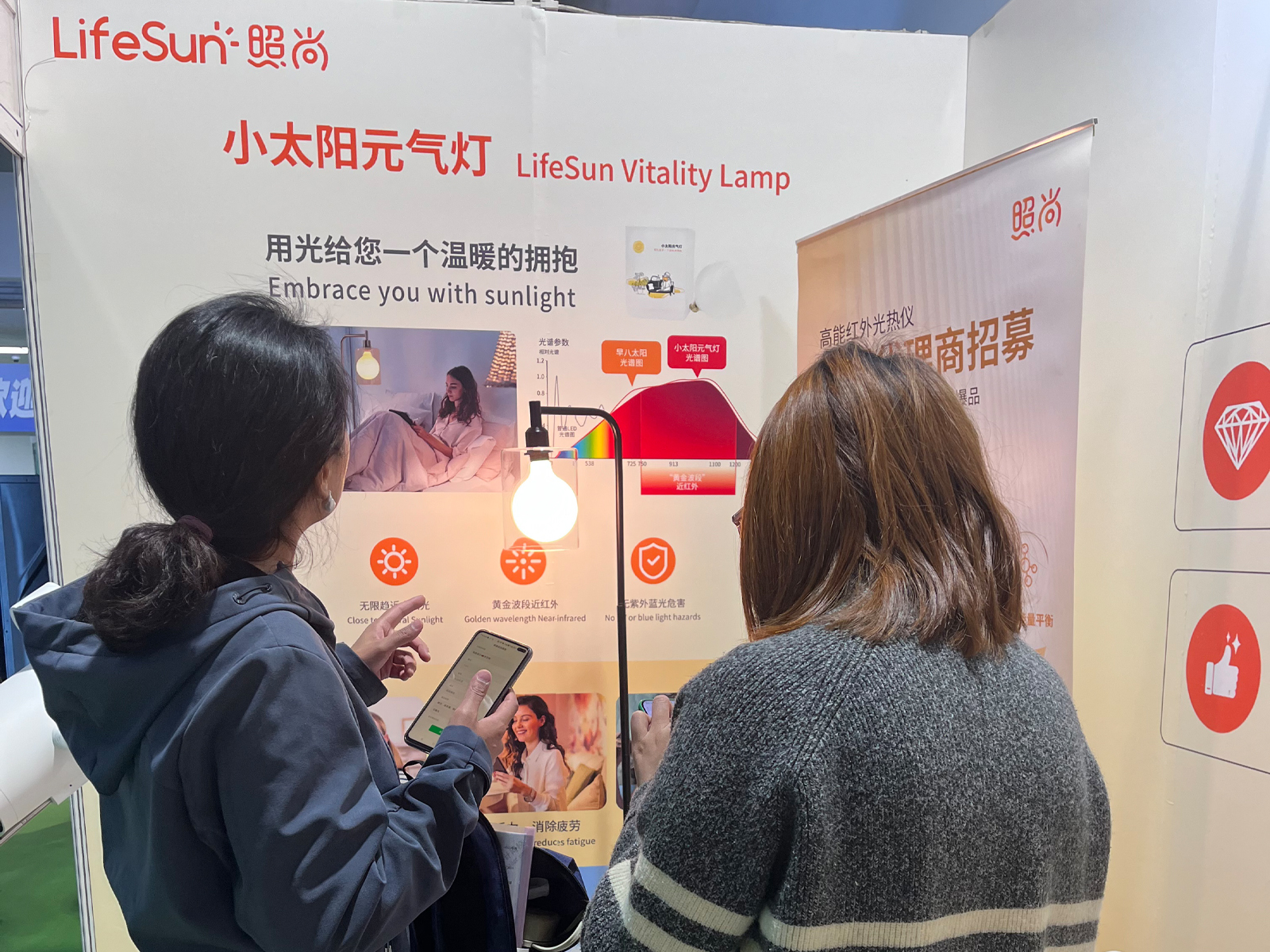 客户在照尚健博会展位咨询小太阳元气灯